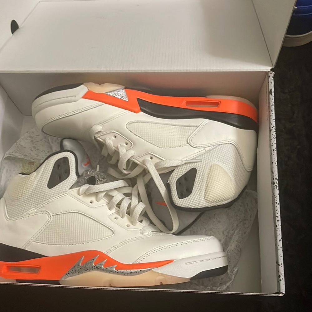 Pair of orange and creamy white Jordan 5s